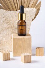 A premium cosmetic dropper bottle displayed on a wooden podium, accompanied by smaller wooden