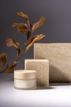 A stylish presentation of a cosmetic cream jar, set against a background of natural stone podiums
