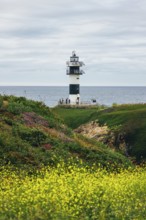 A picturesque lighthouse stands tall on a coastal cliff, overlooking the serene ocean. Bright