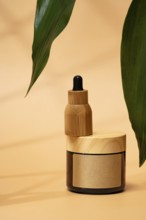 A cosmetic bottle with a wooden cap on a warm beige background, accented by green leaves. The