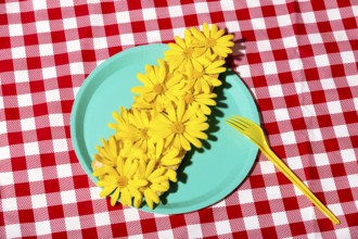 A visually striking arrangement of fresh yellow flowers on a vibrant turquoise plate set against a