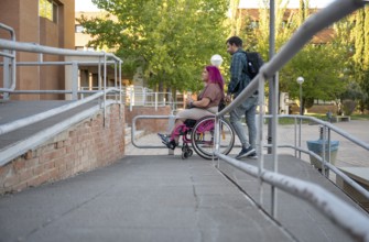 A couple navigating their college campus, with the woman using a wheelchair due to spina bifida