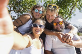 A cheerful group of LGBTQIA+ couples enjoying a sunny day outdoors. Their happy expressions and