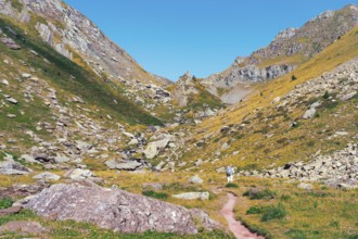 Back view of unrecognizable hikers on a trail in the Ibones de Anayet, Huesca, Spain. This image