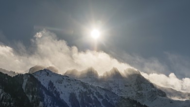 Dramatic winter morning with bright sun shining over the snow covered Les Dents du Midi peaks in