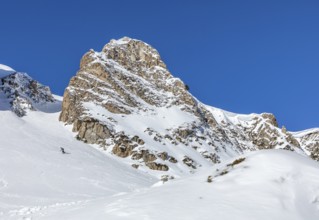 A stunning snow covered mountain peak under a clear blue sky, perfect for winter adventures and the