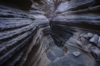 Intricate volcanic rock formations showcasing layered textures inside the popular natural cave in