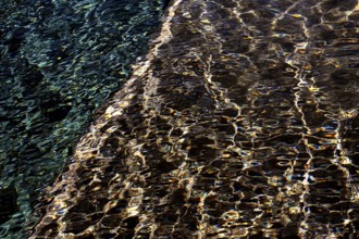 Abstract ripples on the water surface captured at Playa Blanca Port in Lanzarote, illustrating a