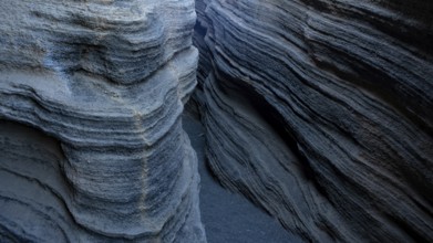 Enigmatic, winding rock formations in Lanzarote, showcasing textured geological layers in shades of