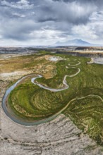 A breathtaking aerial drone photograph captures a winding river snaking through the rugged terrain