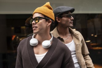 A Colombian gay couple enjoying a relaxed moment together. They wear fashionable clothes,