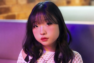 Portrait of an Asian Gen Z girl enjoying the vibrant lights and atmosphere of an arcade Her