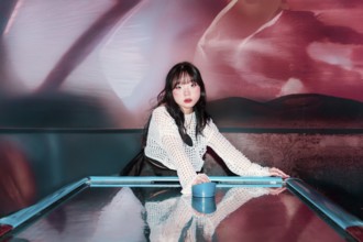 An Asian Gen Z girl enjoys a thrilling moment in an arcade, immersed in vibrant surroundings Her