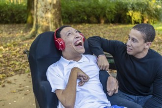 Spanish Cameroonian siblings share a joyful outdoor moment at a park. One sibling, wearing