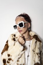 Fashion-forward woman wearing a faux fur coat and oversized white sunglasses, showcasing trendy