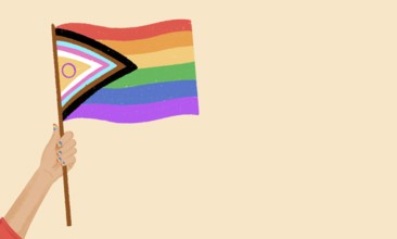 A hand with colorful nails holds an inclusive pride flag against a neutral background. Representing