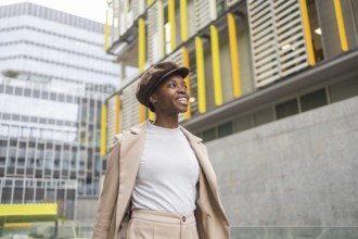A fashionable black woman walks through an urban area, surrounded by contemporary architecture Her