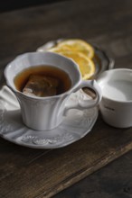 An elegant setting featuring a white porcelain tea cup with an embossed design, filled with English