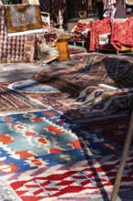A vibrant collection of traditional Georgian rugs and textiles displayed in an outdoor market in