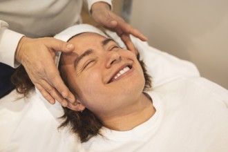 A man enjoys a relaxing facial massage using organic products The atmosphere is serene, promoting
