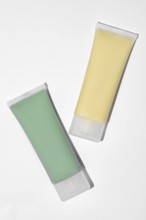Two skincare face mask tubes, on white background. The green tube contains a spirulina, kaolin, and