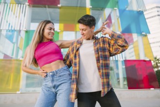 A joyful lesbian couple shares a playful dance, smiling and enjoying the moment. The vibrant glass