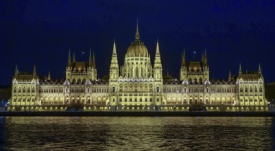 The Hungarian Parliament Building, illuminated at night, reflects its grandeur on the waters of the