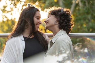 A lesbian couple shares a tender moment, smiling warmly at each other in the soft glow of sunset,