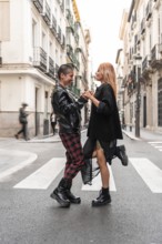 A joyful lesbian couple with unique styles, holding hands and smiling on a lively city street,