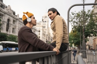 A Colombian couple enjoys a moment together in Madrid city, one listening to music with headphones,