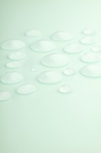 Droplets scattered on a smooth mint green surface, creating a calming and refreshing scene Soft