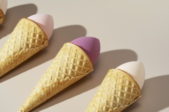 Innovative arrangement of colorful cosmetic sponges nestled in waffle cones, set against a soft,
