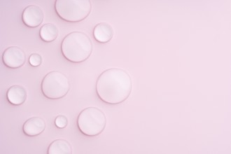 This image displays a pastel pink background with clear droplets, creating a serene and calming
