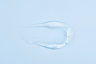 A translucent blue gel-like substance with a smooth, creamy texture, smeared in an elegant, fluid