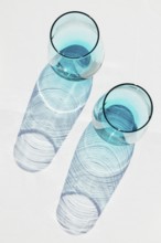 Top view of transparent glasses filled with blue placed on white table