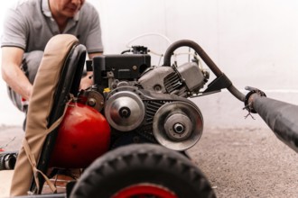 Cropped unrecognizable man is focused on repairing a red engine, showcasing mechanical skills and
