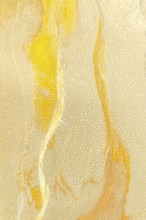 A detailed view of a cracked golden mud surface with flowing yellow lines and intricate patterns,