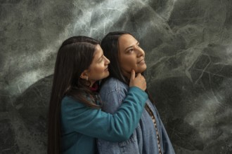 A Latin lesbian couple shares a loving embrace, expressing warmth and affection. The tender moment