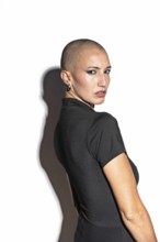Portrait of a middle-aged woman with a shaved head in a black top, exuding confidence. She is