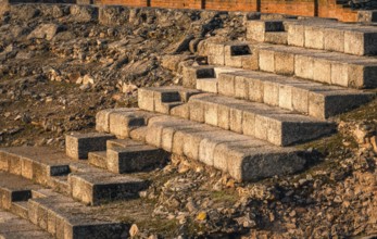 Warm sunlight casts over the stone steps of the ancient Roman theatre in Merida, Badajoz, Spain.