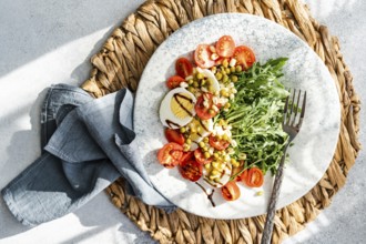 Delicious and nutritious keto salad featuring boiled eggs, fresh rocket, cherry tomatoes, canned