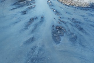 An aerial view of a lagoon in Toledo, Spain, revealing intricate water channels and sediment