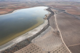 Aerial view of Toledo Lagoons, Spain, showcasing a serene lake amidst farmland. Home to diverse