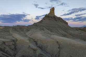 Majestic views of a unique rock formation against a vibrant sunset in Utah, capturing the serene