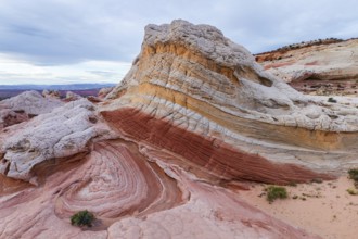 Striking natural sandstone formations showcase swirling patterns and vibrant contrasting colors in