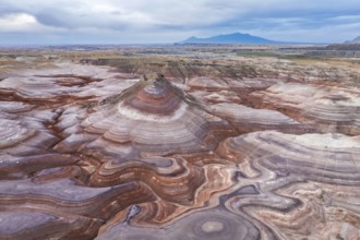 A captivating drone image of an unrecognizable person standing on the unique, multicolored rock