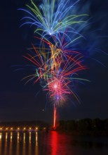 A stunning display of multicolored fireworks illuminates the night sky above the Ebro River, with