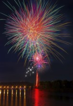 A stunning fireworks show illuminates the night sky above the Ebro River, casting vibrant