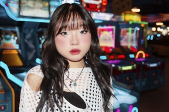 Asian Gen Z girl explores a vibrant arcade, surrounded by colorful lights and games Her expressive