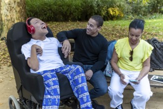A Spanish Cameroonian family enjoying time outdoors. One sibling with cerebral palsy is engaged